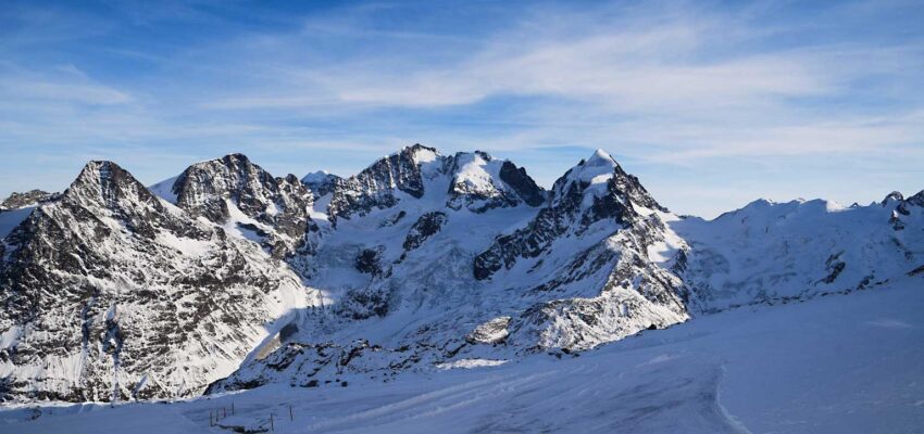 Saint-Moritz - Samedan, montagnes enneigées, ciel bleu clair.