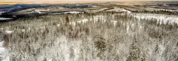 Hélicoptère rouge au coucher du soleil, montagnes en arrière-plan.
